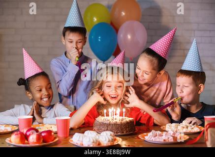 Kids guardando alla torta di compleanno con candele Foto Stock