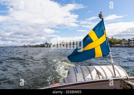 Schwedische Flagge am Schiff bei der Stadtrundfahrt auf der Ostsee in der Innenstadt von Stockholm, Schweden *** bandiera svedese sulla nave durante il c Foto Stock