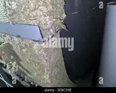 L'isolamento in lana minerale viene utilizzato in un cantiere edile. Il materiale viene posizionato contro la struttura metallica. Ciò garantisce protezione termica e acustica Foto Stock