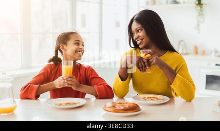 Mamma e figlia possono gustare la colazione insieme in una Bright Kitchen con cibo e bevande Foto Stock