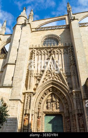 Siviglia, Andalusia, Spagna, una vista dall'angolo basso dell'elaborata facciata gotica della maestosa cattedrale di siviglia, che mostra intricate sculture in pietra, Grand ar Foto Stock