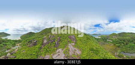 Drone a 180 gradi, vista dalla spiaggia di Cap ternay, mangrovie, pietre di granito, vecchia scuola di New York, isola circostante, lussureggiante foresta verde, Mahe, Seychelles Foto Stock