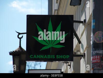 Cracovia, Polonia – 14 aprile 2026: Insegna del negozio di cannabis sulla strada. Simbolo verde della foglia di marijuana montato sull'esterno del ripiano urbano. Cannabis moderna. Foto Stock
