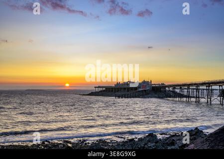 Tramonto accanto al molo di Birnbeck sul canale di Bristol a Weston-super-Mare, Somerset, Inghilterra, con ampia vista sulla costa Foto Stock