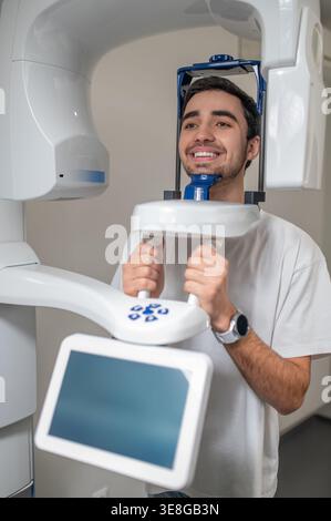 Paziente di sesso maschile che utilizza tomografia computerizzata a fascio conico dentale Foto Stock