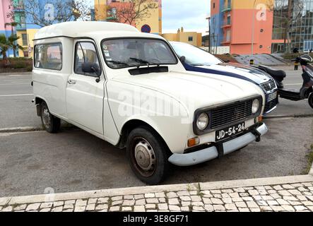 Classico furgone bianco Renault 4 F6 parcheggiato in una strada di Albufeira in Portogallo contro edifici colorati Foto Stock