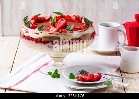 Dessert trifle alla fragola con strati di crema e menta in ciotola di vetro Foto Stock