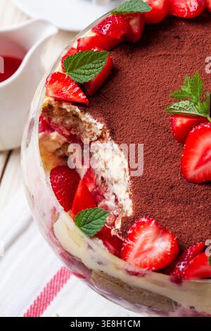 Dessert trifle alla fragola con strati di crema e menta in ciotola di vetro Foto Stock