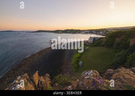 Vista panoramica del tramonto estivo sull'affascinante villaggio balneare di Aberdour da Hawcraig Point sul Firth of Forth lungo il Fife Coastal Path a Scotlan Foto Stock