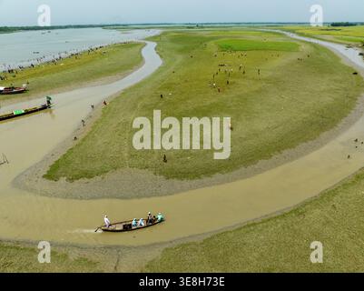 Vista aerea dei tortuosi corsi d'acqua scavati attraverso il vibrante paesaggio verde, con barche che scivolano lungo il fiume, Charmonai, Barisal Division, Bangla Foto Stock