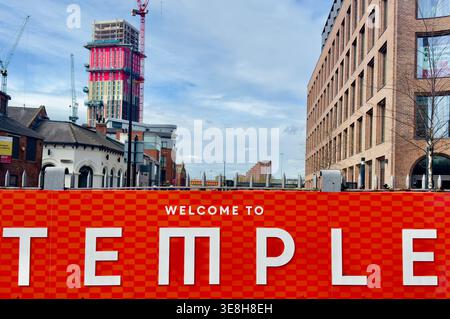 Benvenuto al Temple, insegna in primo piano con l'architettura contemporanea e la costruzione attiva alle spalle, evidenziando la rigenerazione nel West Yorkshire Foto Stock