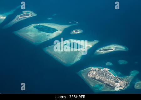 Vista aerea delle isole sparse come gioielli di smeraldo tra il mare zaffiro, un paradiso tropicale si dispiega dall'alto, volo da male a Hanimaad Foto Stock