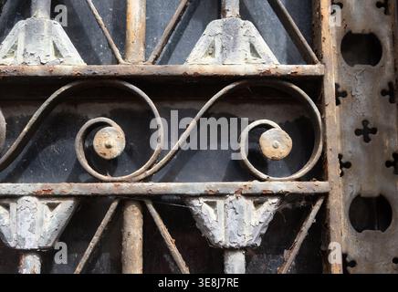 primo piano di un antico cancello o recinto in ferro battuto rustico con design geometrico di forme vecchio e arrugginito sfondo orizzontale o sfondo Foto Stock