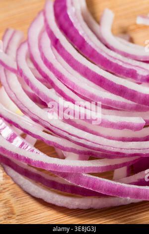 Cipolle rosse con taglio crudo organico su un tagliere Foto Stock