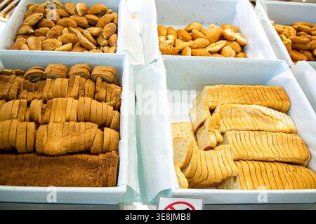 Primo piano della sezione di panetteria a buffet dell'hotel nel resort della Repubblica Dominicana con vassoi rivestiti di carta con panini appena sfornati, panini di sesamo, semi di papavero Foto Stock