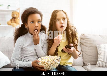 I bambini guardano il canale Discovery e mangiano popcorn Foto Stock