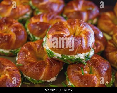 Bagel al burro di sale intrecciato vassoio in legno per panetteria artigianale a tiratura larga. Questa immagine presenta bagel intrecciati larghi, più bagel. All'interno di un'accogliente panetteria artigianale Foto Stock