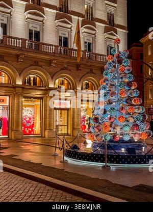 Un albero di Natale di fronte al negozio Fendi, in largo Carlo Goldoni, una piccola piazza di Roma Foto Stock