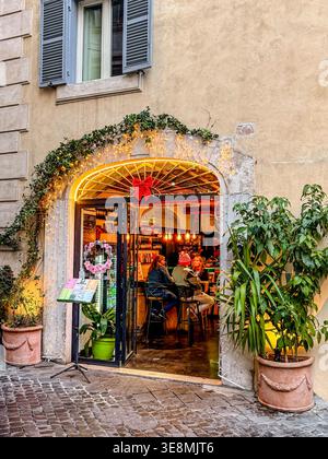 Persone che si godono un drink al caffè & libri, un negozio di libri e bar in Piazza dell'Orologio, Roma, Italia Foto Stock