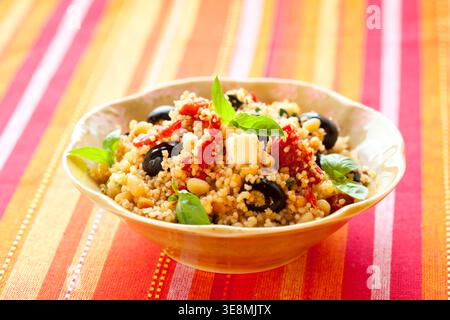 insalata di couscous mediterraneo con pomodori secchi, feta, olive e basilico Foto Stock
