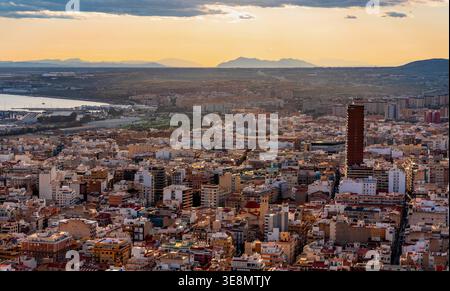 Alicante, Spagna - 20 gennaio 2026: Paesaggio urbano panoramico di Alicante con i quartieri urbani centrali e la catena montuosa della Sierra Fontcalent vista dal Monte Be Foto Stock