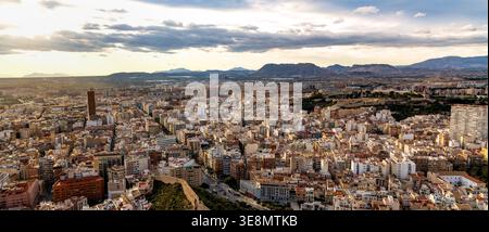 Alicante, Spagna - 20 gennaio 2026: Paesaggio urbano panoramico di Alicante con i quartieri urbani centrali e la catena montuosa della Sierra Fontcalent vista dal Monte Be Foto Stock