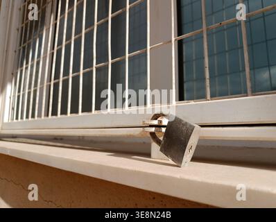 Lucchetto sulle barre di sicurezza dei finestrini alla luce del sole Foto Stock