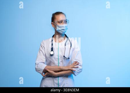 Donna medico professionista che indossa maschera e occhiali di protezione Foto Stock