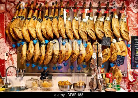 Il jamon iberico bellota pata negra è esposto in un negozio a Granada, Spagna. I clienti possono gustare questo famoso prosciutto. Foto Stock