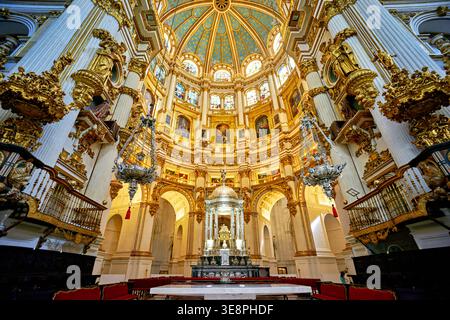 I visitatori osservano gli splendidi dettagli della Capilla Mayor all'interno della cattedrale di Granada in Andalusia. La luce riempie lo spazio durante il giorno. Foto Stock