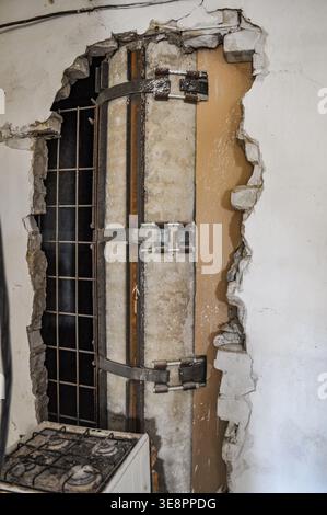 Vista ravvicinata di una colonna in cemento rinforzata con travi a i in acciaio e cinghie metalliche come parte di un progetto di riparazione strutturale Foto Stock
