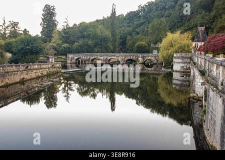 Un tranquillo paesaggio caratterizzato dall'esclusivo "Pont Coudé" (ponte a gomito) del XVI secolo che si riflette sulle calme acque del fiume Dronne nel velo medievale Foto Stock
