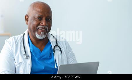 Medico che utilizza un computer portatile per la cura del paziente in ambiente clinico durante il giorno Foto Stock