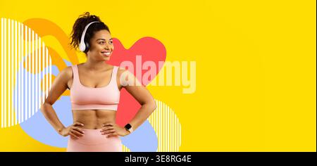 Joyful African American Woman gode di musica in allenamento outfit su sfondo giallo brillante Foto Stock