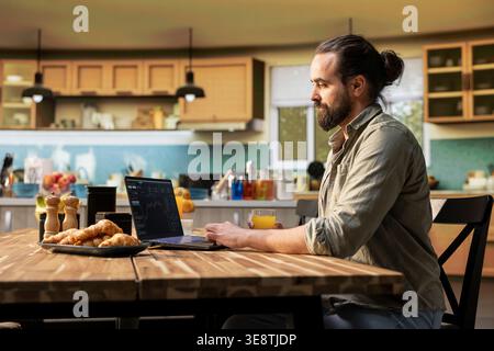 Stockbroker a casa, fluttuazioni di trading giornaliere, monitoraggio delle tendenze di mercato, grafici a candele su laptop, rischio di ricerca per gli investimenti, analisi delle borse, profitto delle criptovalute. Foto Stock