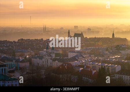 Vista aerea dei tetti storici della città vecchia e delle guglie della chiesa avvolte nella nebbia dorata del mattino a Varsavia, nel voivodato della Masovia, in Polonia. Foto Stock