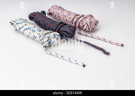 Collezione di tre funi intrecciate a spirale che mostrano diverse combinazioni di colori: Bianco con motivo a diamante blu, blu scuro con rifiniture rosse e beig Foto Stock