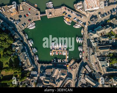 Vista aerea dall'alto verso il basso del porto di Padstow, Cornovaglia, con barche ormeggiate nelle acque verde smeraldo del porto mareale, Inghilterra, Regno Unito, maggio 2025 Foto Stock