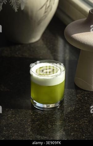 Cocktail verde con schiuma e fetta di kiwi Foto Stock