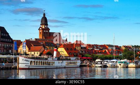 Waren, Germania, 22-08-2017 Descrizione: Porto di Waren Muritz con barche e chiesa di Marienkirche, Germania. Foto Stock