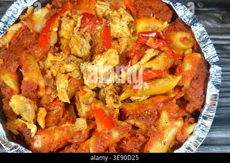 Una casseruola di pasta egiziana, popolare cibo di strada egiziano, consiste tipicamente di penne cotte in una salsa di pomodoro rosso condita e pezzi e condite Foto Stock