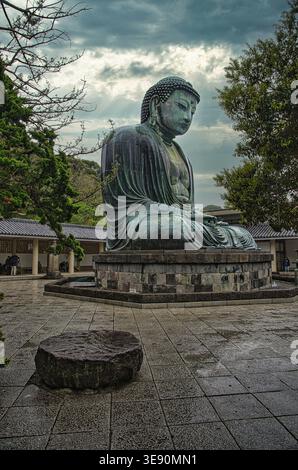 Il grande Buddha di Kamakura (Daibutsu) al Tempio di Kotoku-in sotto un cielo nuvoloso in un giorno di pioggia, prefettura di Kanagawa, Giappone Foto Stock