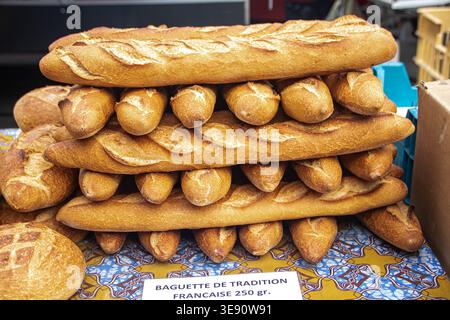 Una pila di "baguette de Tradition Francaise" appena sfornata in un mercato a Brantome, Perigord. La foto mostra la classica forma lunga e i punteggi Foto Stock