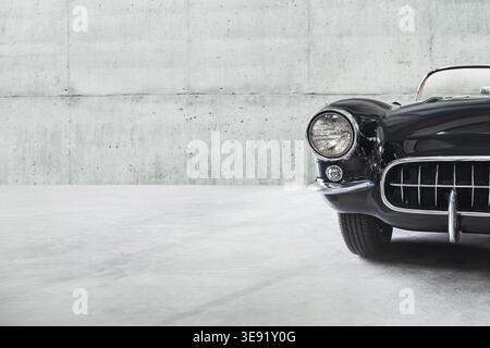 Il faro della vecchia e bellissima auto di lusso sullo sfondo di un muro di cemento. Foto Stock