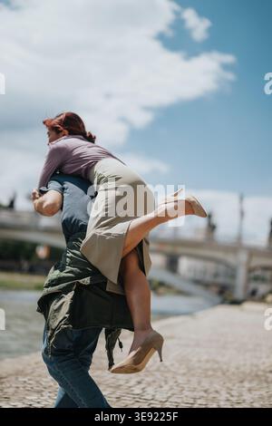 I colleghi giocosi condividono un momento di vita lungo il fiume e un ponte con un abbigliamento casual per affari Foto Stock