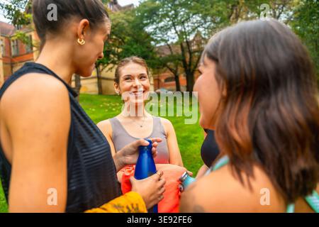 Tre diverse donne amiche che parlano e sorridono all'aperto Foto Stock