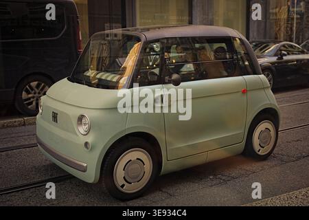 Una mini Fiat nel cuore di Milano, Lombardia, Italia. La macchina delle due sitter sembra essersi fermata su un segnale Foto Stock