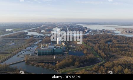 Vista aerea della centrale elettrica Vattenfall Elektriciteitscentrale Diemen con edifici industriali e torri di raffreddamento vicino a corsi d'acqua e foreste in Die Foto Stock