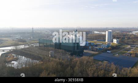 Vista aerea della centrale elettrica Vattenfall Elektriciteitscentrale Diemen con pannelli solari e strutture industriali circondate da alberi e acqua in D Foto Stock