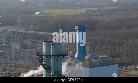 Vista aerea della centrale elettrica Vattenfall Elektriciteitscentrale Diemen con camini industriali che emettono vapore vicino a una sottostazione elettrica a Dieme Foto Stock